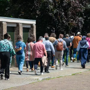 Deelnemers van de sessie Bewonersbetrokkenheid lopen door een wijk